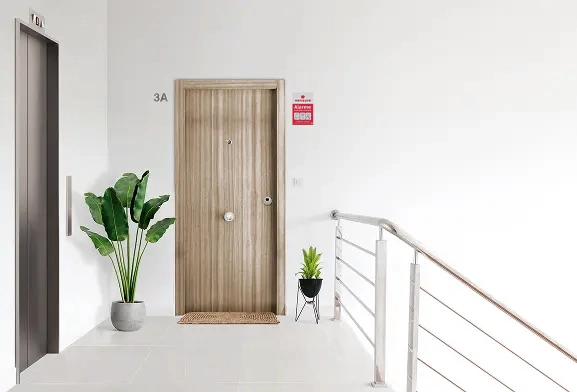 Placa disuasória do alarme da Verisure colocado sobre uma parede branca na entrada de um apartamento